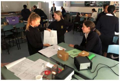 Year 9 students investigating light while using their teacher made workbooks
